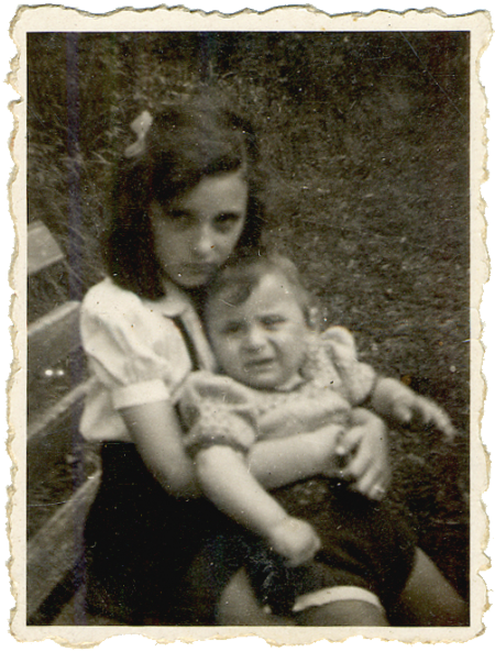 Black-and-white photograph of a girl sitting on a bench, holding a young toddler on her lap. The girl has a bow in her hair. The two siblings look at the camera, neither of them smiling.