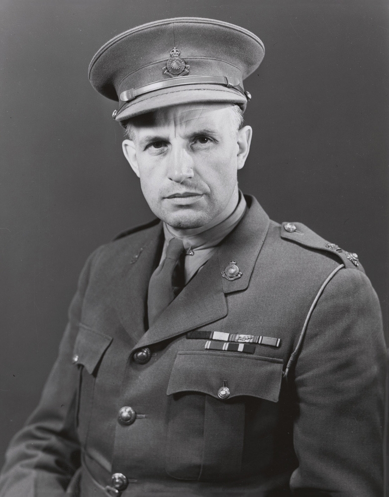 Black-and-white portrait photograph of a man, visible from his waist up, wearing a military suit.