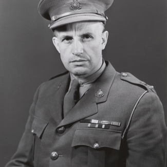 Black-and-white portrait photograph of a man, visible from his waist up, wearing a military suit.