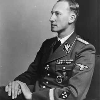 Portrait photographique en noir et blanc d'un homme regardant vers la gauche de la caméra, visible de la taille, portant un uniforme militaire.